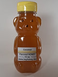 Bee-shaped bottle of coconut honey with a yellow cap on a white background
