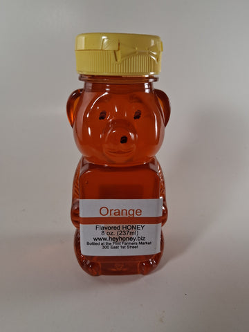 Orange honey bottle with a label on a white background