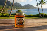 Hawaiian Lemon Blossom honey 12 oz jar on a wooden deck overlooking a tropical Hawaiian bay with palm trees and mountains at golden hour | HeyHoney.biz