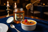 Turkish Sunflower Limoncello honey drizzled from a honey dipper onto crème brûlée with raspberry in a candlelit restaurant setting | HeyHoney.biz